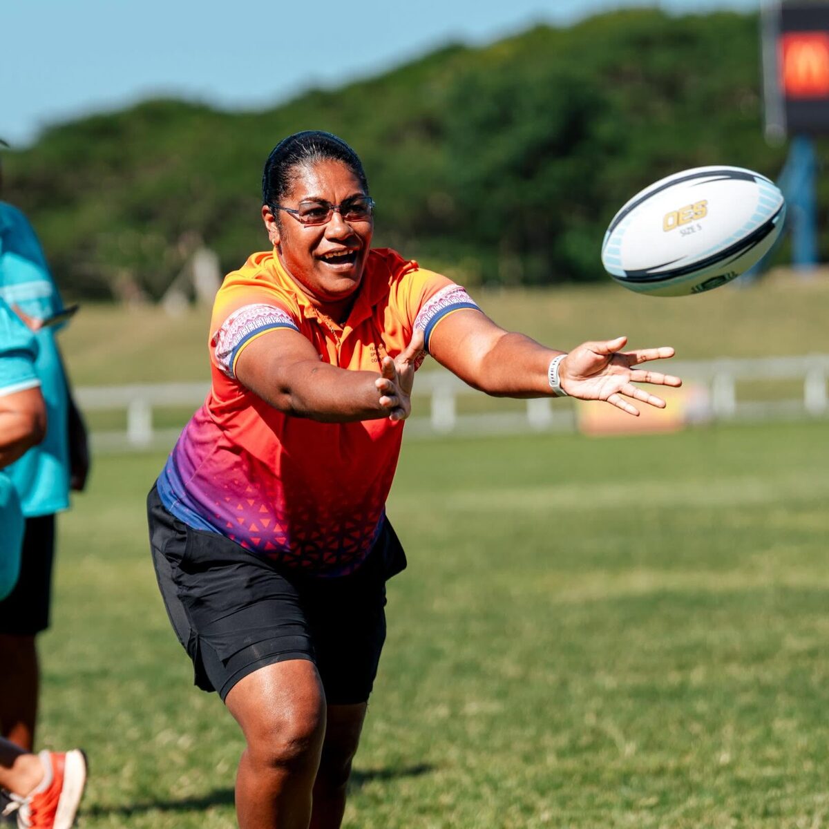 Woman passing a rugby ball